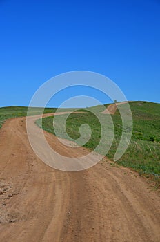 Winding road in the green field.