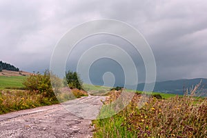 Kľukatá cesta cez kopce na pozadí pohoria Západné Karpaty
