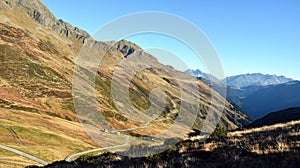 A winding road is laid along the mountain slope in perspective. Natural scenic landscape and hiking trails