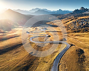 Winding road in mountain valley at sunset in autumn. Aerial view