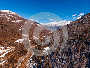 Winding road in mountains of Italy Alps. Sunny day. Aerial top view