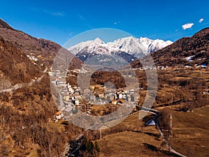 Winding road in mountains of Italy Alps. Sunny day. Aerial top view