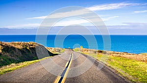 Winding road on the Pacific Ocean coastline on a clear sunny day, Point Reyes National Seashore, California