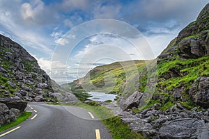 Winding road running through Gap of Dunloe with view on lake and green hills, Black Valley