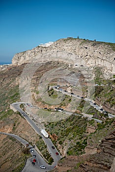 Winding road, serpantine, cars going up the hill in Santorini island, Greece