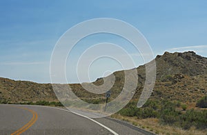 Winding road with a speed limit sign on the roadside to Montana