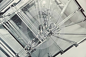 Winding stairs with clear glass steps in spacious light hall