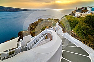 Winding steps down the hill of Santorini island, Greece, at sunset.