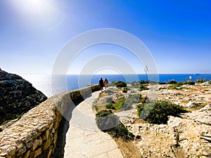 Winding stone wall and walking path along the ocean