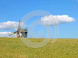 Windmill behind the hill and cloud