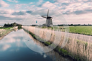 Windmill and Canal on Traditional Holland Landscape