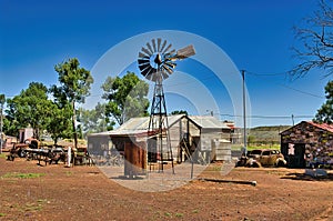 Windmill, deserted house and rusty old cars in a ghost town in Australia