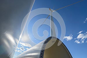 Windmill for electric power production. Silhouette of wind turbines at sun flares. The concept of alternative green energy