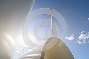 Windmill for electric power production. Silhouette of wind turbines at sun flares. The concept of alternative green energy