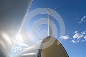 Windmill for electric power production. Silhouette of wind turbines at sun flares. The concept of alternative green energy