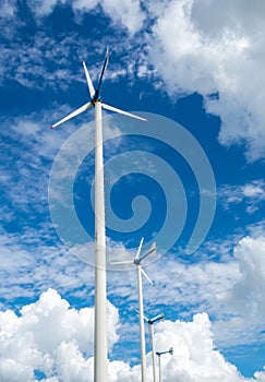 Windmill farm for alternative clean energy with clouds and blue