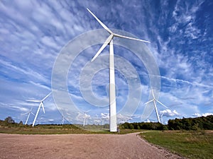 Windmill farm among fields and small trees. European Environment Initiative. Conservation of energy and fossil resources. Zero