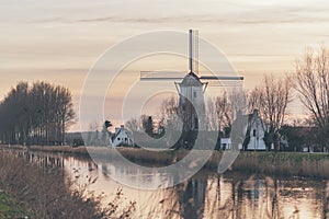 Windmill and farm houses alongside a canal