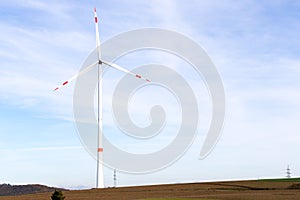 A windmill on a field with blue sky