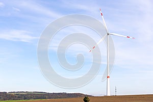 A windmill on a field with blue sky