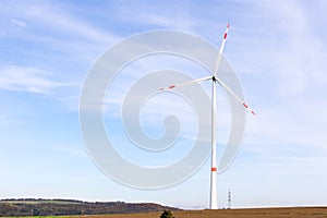 A windmill on a field with blue sky