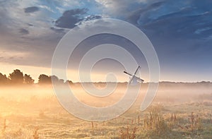 Windmill in fog at sunrise