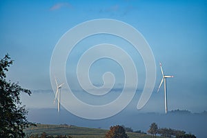 Windmill in foggy landscape. Renewable energy for environmentally conscious future