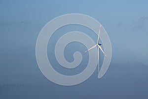 Windmill in foggy landscape. Renewable energy for environmentally conscious future