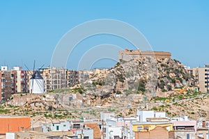 Windmill and fortress on Monte Sacro viewed from archeological park on cerro del molinete in Cartagena, Spain photo