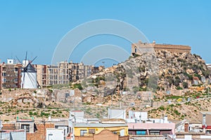 Windmill and fortress on Monte Sacro viewed from archeological park on cerro del molinete in Cartagena, Spain photo