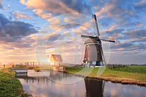 Windmill near the water canal at sunrise in Netherlands