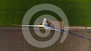 Windmill producing alternative energy in field. Wind tower creating eco power.