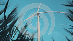 Windmill with propeller against blue sky view from wheat