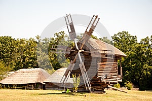 Windmill in a rural area. Wind Farm. Dutch windmill. Landscape with traditional Ukrainian windmills houses in countryside village