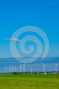 Windmill set.Green energy.Wind generator and home in green field.Windmills on blue sky background.renewable energy.