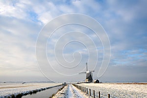 Windmill in the snow in a dutch minimalistic landscape