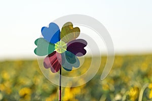 Windmill toy on yellow field background. Alternative energy concept