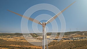 Windmill turbine blades close up against blue sky. Plant generate green alternative energy in desert