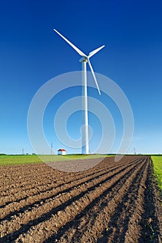 Windmill turbine on blue sky. Wind energy. Modern green power.