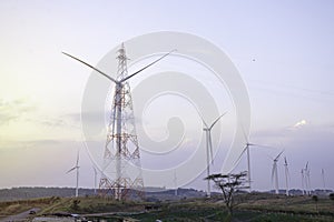 Windmill turbine farm for electricity generation on landscape mountain at sunset sky