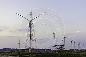 Windmill turbine farm for electricity generation on landscape mountain at sunset sky photo