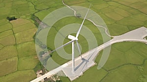 Windmill turbine on green field background. Drone view wind power turbine generation on energy station. Alternative