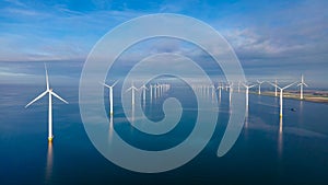 Windmill turbines at sea seen from a drone aerial view from above at a huge windmill park