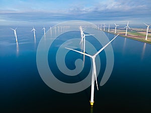 Windmill turbines at sea seen from a drone aerial view from above at a huge windmill park