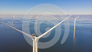 Windmill turbines at sea seen from a drone aerial view from above at a huge windmill park