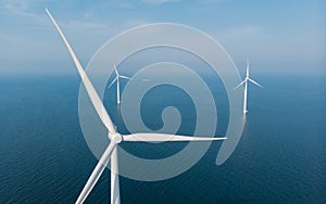 Windmill turbines at sea seen from a drone aerial view from above at a huge winmill park