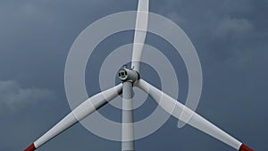 Windmill or wind turbine on wind farm in rotation photo