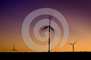 Windmill Wind Turbine Spinning in Wind at Sunset or Sunrise