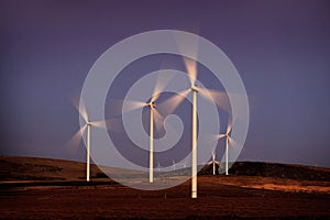 Windmill Wind Turbine Spinning in Wind at Sunset or Sunrise