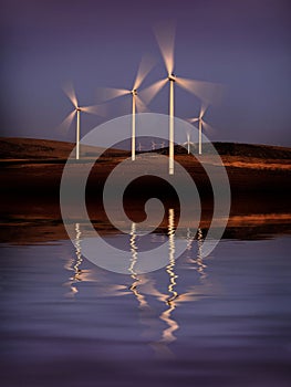 Windmill Wind Turbine Spinning in Wind at Sunset or Sunrise